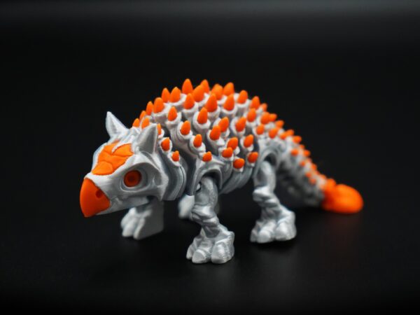 Anquilossauro impresso em 3D nas cores prata e laranja